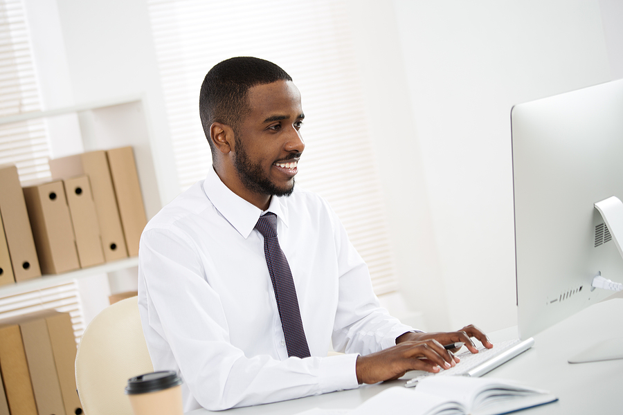 man in office looks at laptop success